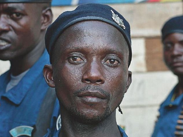 Burundi, A police officer poses with a beer